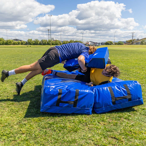 Rugby Tackle Mat, action lifestyle shot, player tackling another player holding a hit shield onto the tackle mat.